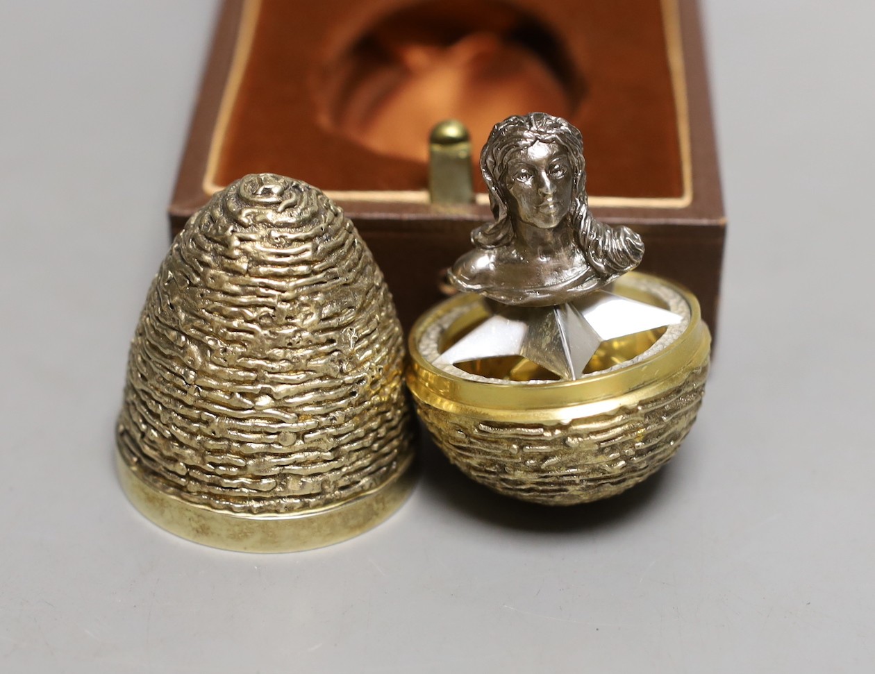 A cased modern silver gilt surprise egg, in the manner of Stuart Devlin, by Richard Lawrence Geere, London, 1976, 67mm, with bust interior.